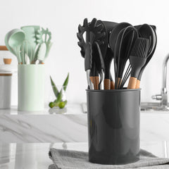 Black kitchen utensil holder with various utensils on a kitchen counter.