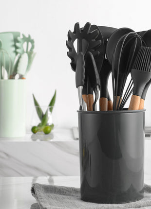 Black kitchen utensil holder with various utensils on a kitchen counter.