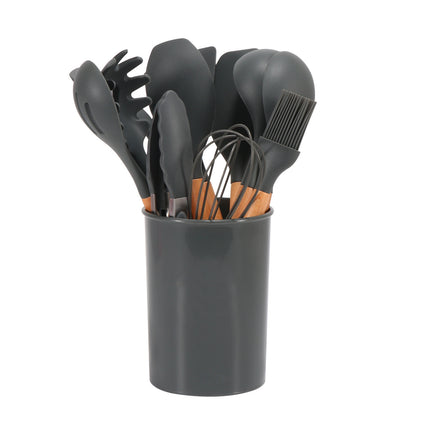Set of black kitchen utensils including spoons, spatulas, and a whisk in a gray holder on a white background.