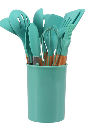 Set of teal kitchen utensils including spatulas and a whisk in a teal holder on a white background
