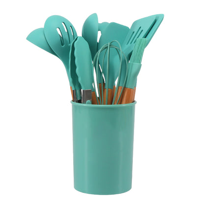 Set of teal kitchen utensils including spatulas and a whisk in a teal holder on a white background