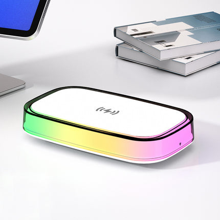 Gradient-colored electronic device on a white surface with books in the background