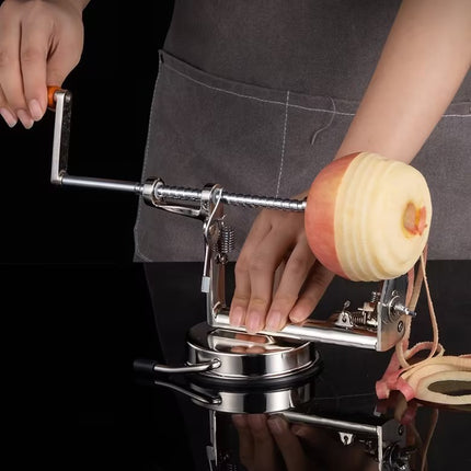 Person using a apple peeler to peel an apple against a black background