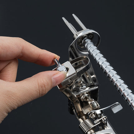 Close-up of a hand using a metal tool on a black background