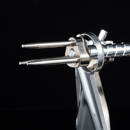 Close-up of a metallic tool with two prongs on a black background