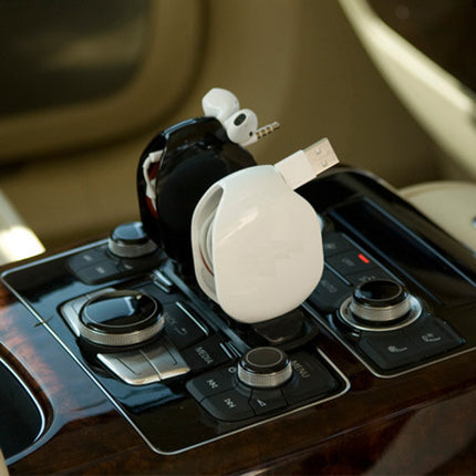 Car gear shift with a white car keychain attached on a blurred interior background