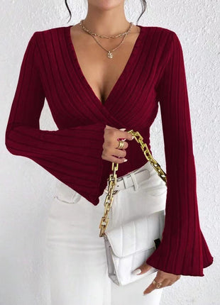 Person wearing a burgundy long-sleeve top with a white background