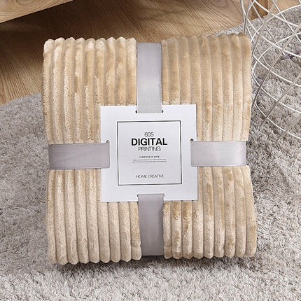 Beige textured blanket with a brand tag on a gray surface