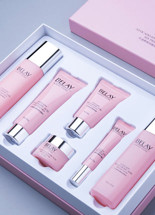 Cosmetic set with pink bottles and containers in a box, featuring the brand 'Belay'.