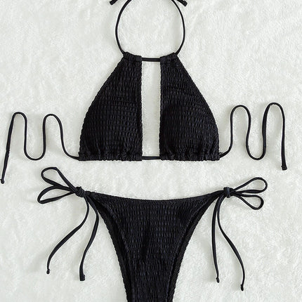 Black bikini set with smocked texture on a textured white background