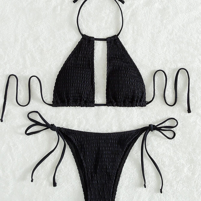 Black bikini set with smocked texture on a textured white background