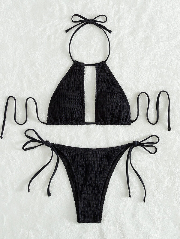 Black bikini set with smocked texture on a textured white background