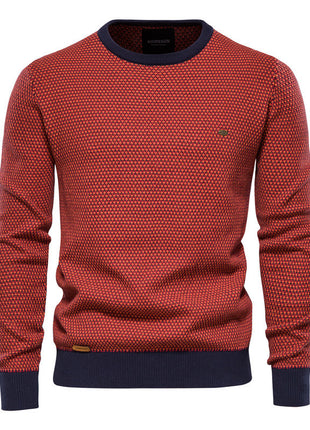 Red patterned sweater with navy cuffs and collar on a white background