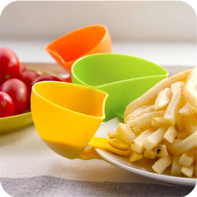Colorful plastic measuring cups on a table with vegetables and pasta.