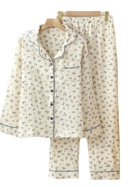 Floral pajama set hanging on a rack with a wooden shelf and books in the background.