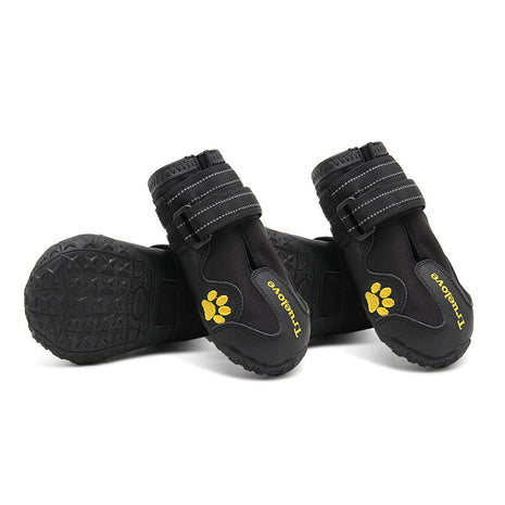Black dog boots with yellow paw prints on a white background