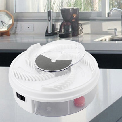 White electronic device on a kitchen counter with a coffee maker and clock in the background