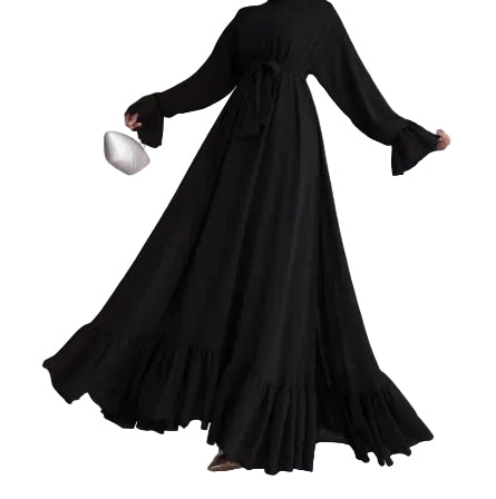 Person wearing a long black dress against a neutral background