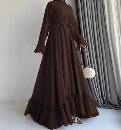 Brown long dress with ruffled sleeves and hem against a neutral background