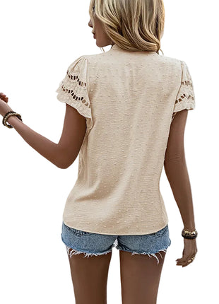 Fashionable short sleeve lace blouse paired with trousers for a polished business casual outfit.