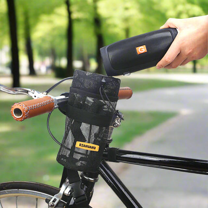 Person using a portable device on a bicycle with a black bag attached to the handlebar.