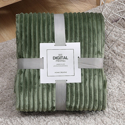 Green textured blanket with a white label on a gray surface