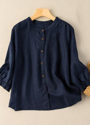 Navy blue shirt on a wooden hanger with a woven bag on a beige background