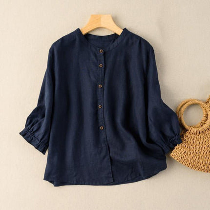 Navy blue shirt on a wooden hanger with a woven bag on a beige background