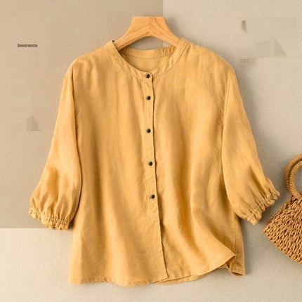 Yellow blouse on a hanger with a woven bag on a beige background