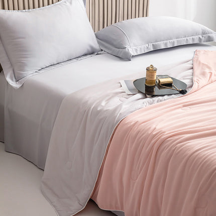 Bed with white bedding and a pink blanket, featuring a small round table with items on it.
