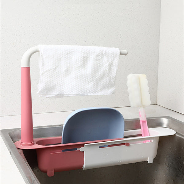 Pink and white dish drying rack with a blue dish inside, hanging over a sink.