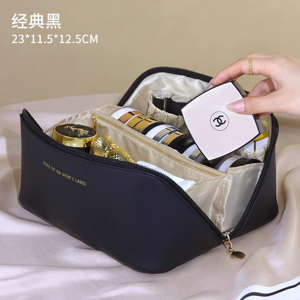 Black cosmetic bag with gold and white items on a beige surface