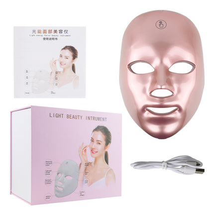 Rose gold LED face mask with packaging and USB cable on a white background