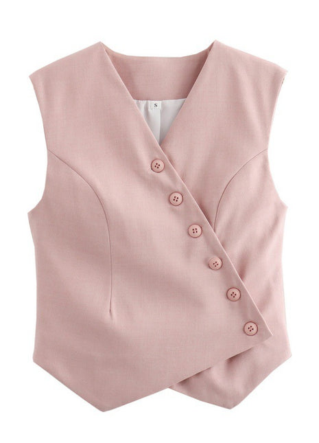 Light pink V-neck asymmetric vest styled with tailored trousers for an elegant smart-casual look.