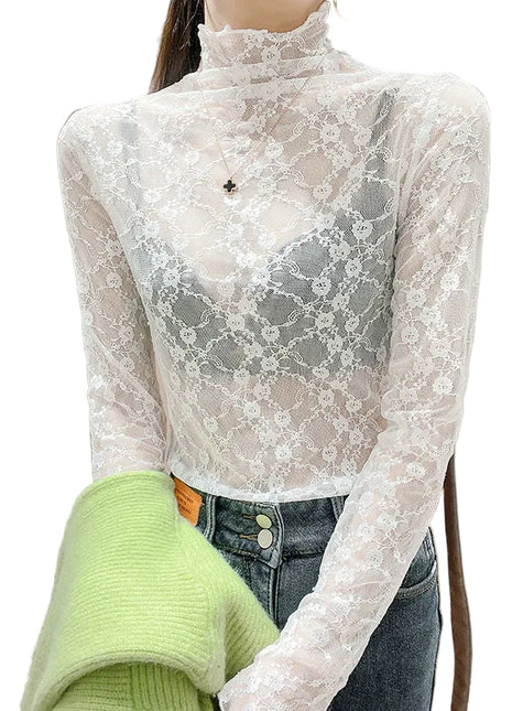 Person wearing a sheer lace long-sleeve top over a green sweater with a neutral background