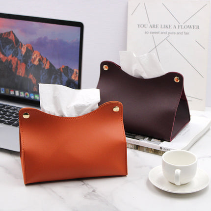 Two leather tissue holders on a desk with a laptop and cup of coffee.