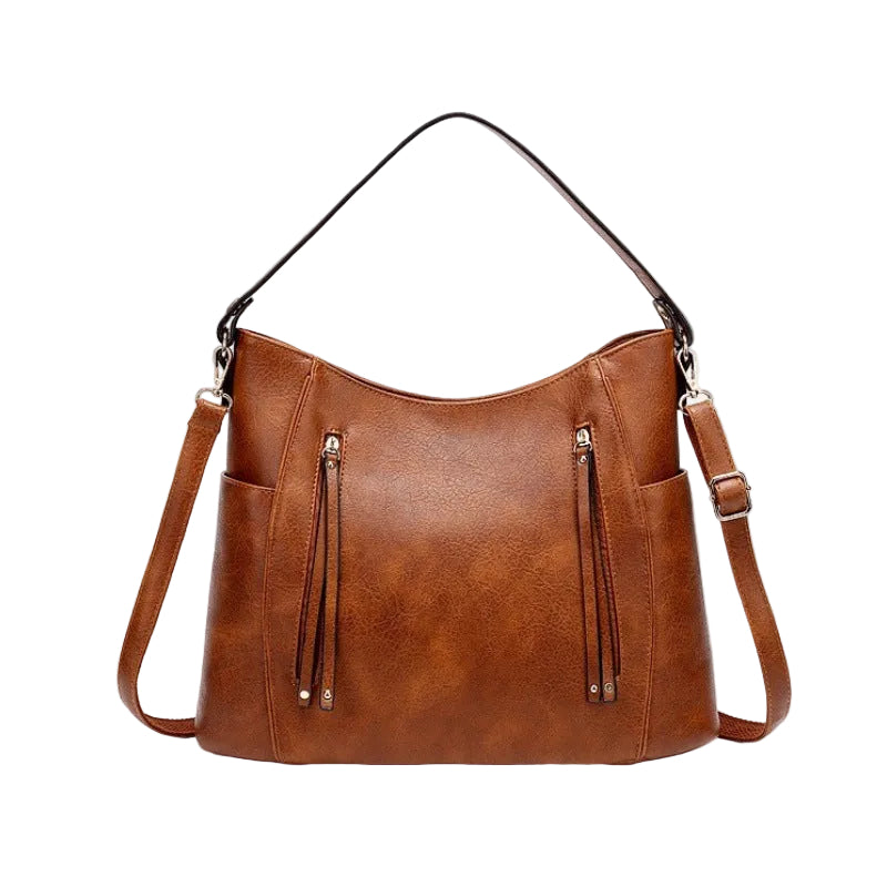 Brown leather handbag with shoulder straps on a white background