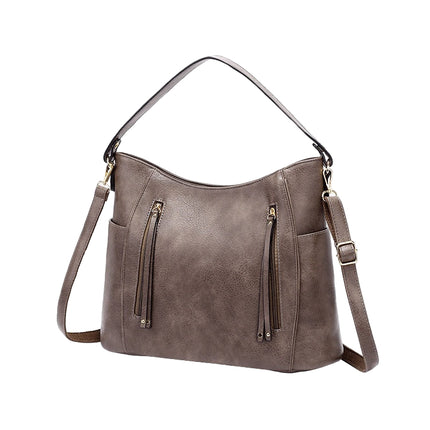 Brown leather handbag with multiple zippers on a white background
