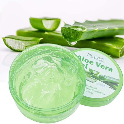 Aloe vera gel jar with fresh aloe leaves on a white background