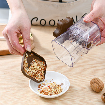 Person using a nutcracker to crush walnuts on a wooden surface.