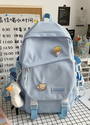 Light blue backpack with cartoon character patches on a desk