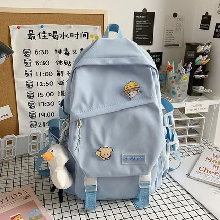 Light blue backpack with cartoon character patches on a desk