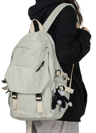 Light gray backpack worn by a person on a white background