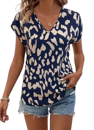 Navy blue short sleeve batwing T-shirt with vibrant digital animal print and flattering cinched silhouette.