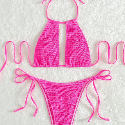 Pink bikini set with mesh design on a textured white background