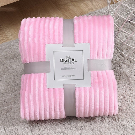 Pink textured blanket with a label on a gray surface