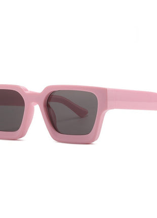 Pink sunglasses with dark lenses on a white background
