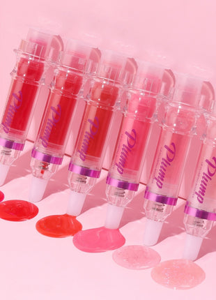 Set of lip gloss tubes with visible brand name on a pink background