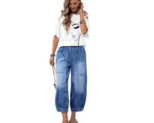 Woman wearing a white t-shirt with a graphic design and blue jeans on a white background