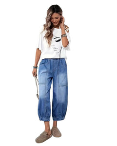 Woman wearing a white t-shirt with a graphic design and blue jeans on a white background